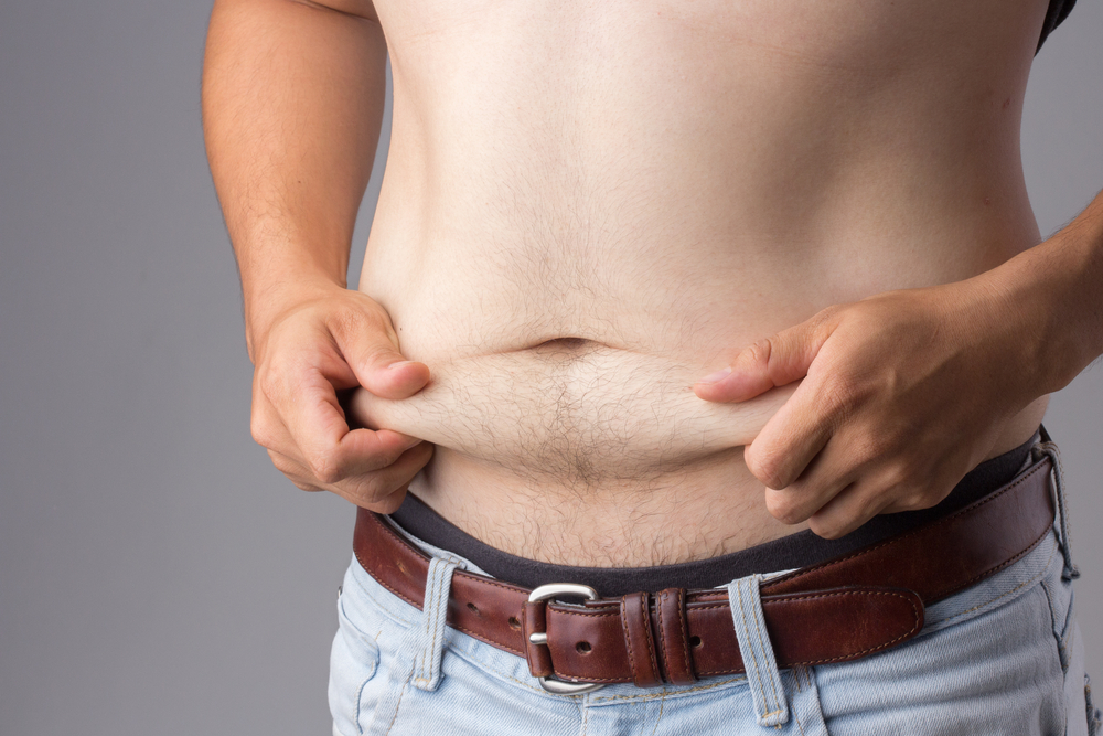 Man grabbing the flab of his dad bod stomach